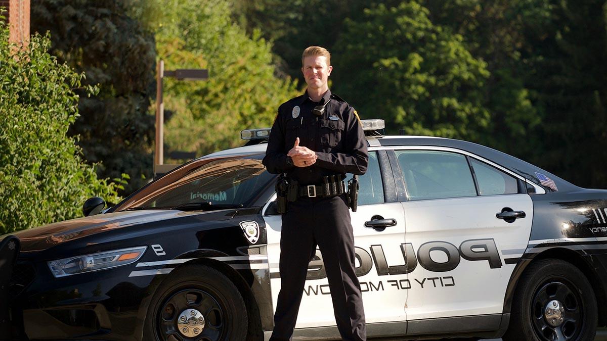 Jason House stands in front of a Moscow police car